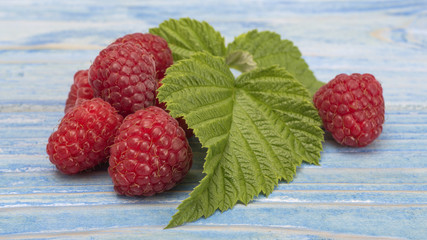 raspberry on a blue wooden background. 