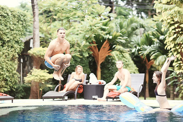 friends have fun in the summer pool at the hotel / cheerful company of young friends of men and...