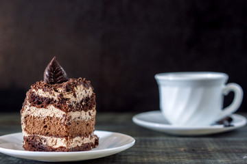 Tasty piece of chocolate cake on wooden table background
