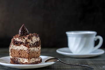 Tasty piece of chocolate cake on wooden table background