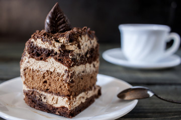 Tasty piece of chocolate cake on wooden table background