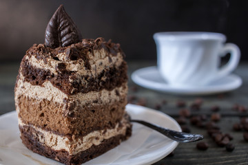Tasty piece of chocolate cake on wooden table background