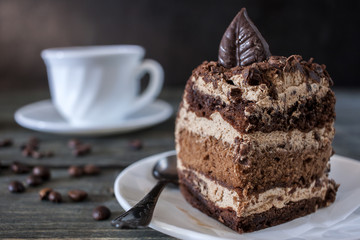 Tasty piece of chocolate cake on wooden table background