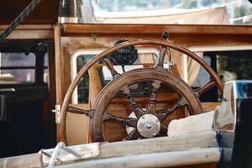 Closeup of a vintage hand wheel on a wooden sailing yacht.