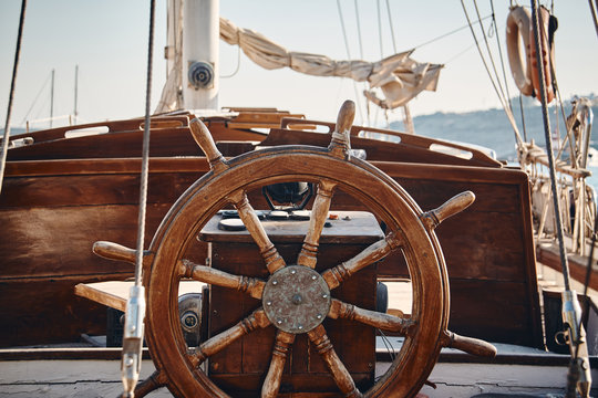 Closeup of a vintage hand wheel on a wooden sailing yacht.