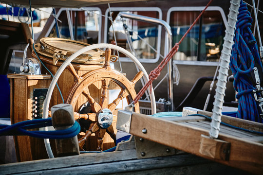 Closeup of a vintage hand wheel on a wooden sailing yacht.