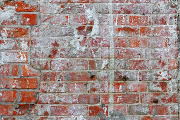 Weathered dirty red brick wall texture with cracks and paint stains. Abstract brick wall background