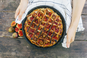 Autumn fig pie or tart with cinnamon on an old wooden table. Top view