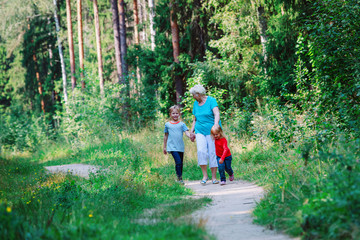 happy senior grandmother with kids walk in nature
