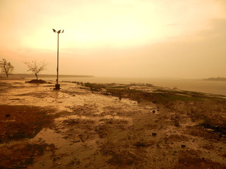 Setting sun on the banks of a huge water reservoir