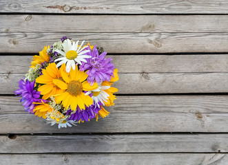 Orange, violet flowers on wooden background, copy space