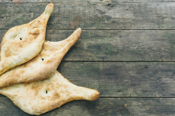 Homemade Georgian bread on a black wooden background. 