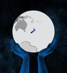 New Zealand on globe in hands