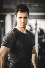 Fototapeta na wymiar Fit caucasian handsome young man and big muscle in sportswear. Portrait of young man action after exercise class in a gym. Healthy sports lifestyle, Fitness concept. with copy space for your text.