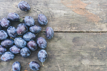 Some fresh plums on the wooden background. Close up. Copy space right.