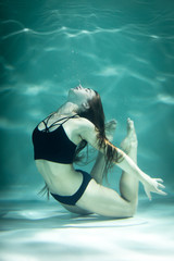 Woman under the water in a black clothes.