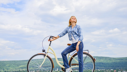 Woman rides bicycle sky background. Reasons to ride bike. Benefits of cycling every day. Keep fit...