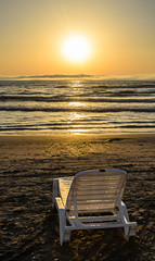 Sunbeds on the beach of Black Sea at sunrise, warm sunshine atmosphere