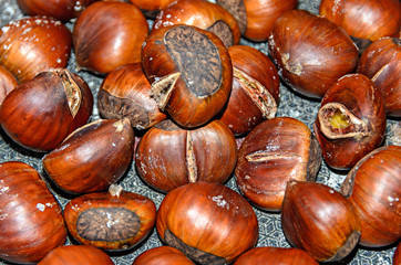 Edible brown cracked chestnuts close up, frying pan