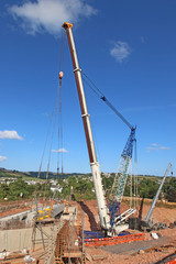 Fototapeta na wymiar Crane lifting a bridge beam