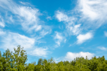 Textured background of blue sky with clouds and forest