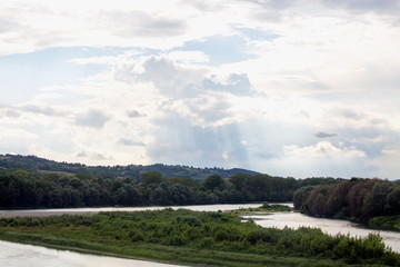 Fototapeta na wymiar River under scenographic cloudy sky