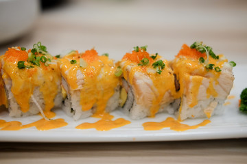 Japanese sushi roll topped with spicy salmon slice