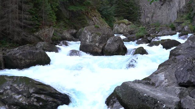 The waterfall and rocks covered with the moss abd grass in the mountain