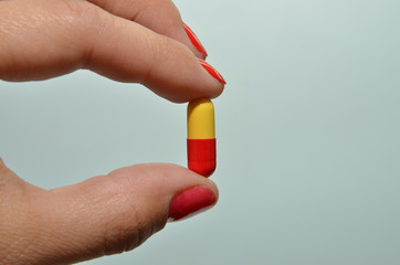 capsule for treatment, a beautiful capsule in the hands of a girl for losing weight