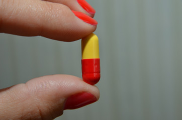capsule for treatment, a beautiful capsule in the hands of a girl for losing weight
