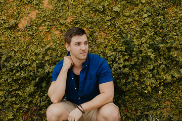 Attractive Male Model in Blue Collared Shirt in front of Orange Textured Vine Wall