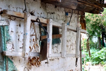Old ladder hanging on a white warehouse in a greek village. 
