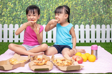 Asian Chinese little sisters eating pizza