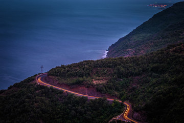 A brightly lit road twisting and curving up a mountain in Long Exposure.