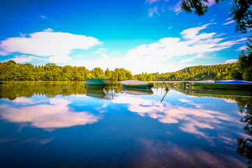 Reflection in water of mountain lakes and boats.