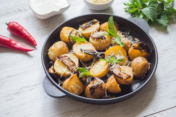 Rustic potatoes with mushrooms on a white wooden table. Top view.

