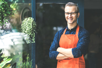 Portrait of happy young man wearing an apron attractive caucasian Male Barista cafe restaurant...