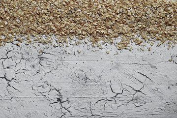 Dry oatmeal on a white wooden background. Top view. Copy space.