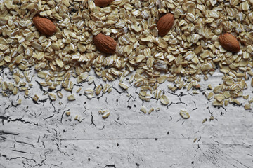 Dry oatmeal with almonds on a white wooden background. Top view. Copy space.