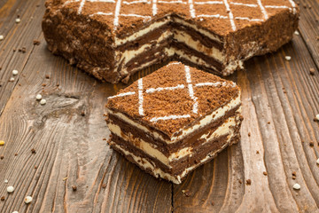 Dark chocolate vegan cake with candies and nuts on wooden background