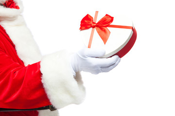 Christmas. Santa Claus in white gloves holds a white heart-shaped gift box with a red ribbon. Isolated on white background. Close up