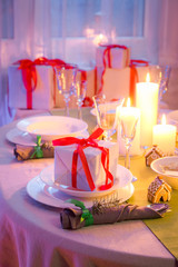Closeup of Christmas table setting with gifts and candles