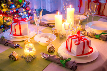 Christmas table setting with candles and gifts