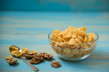 Fototapeta na wymiar Tasty cornflakes with walnut in glass bowl