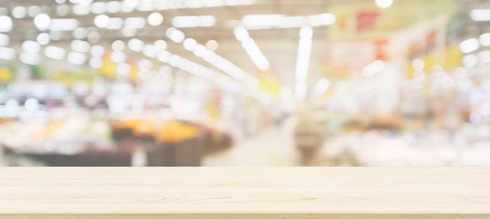 Wood table top with supermarket grocery store blurred defocused background with bokeh light