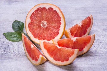 Citrus fruits slices of tropic grapefruits on a wooden background.