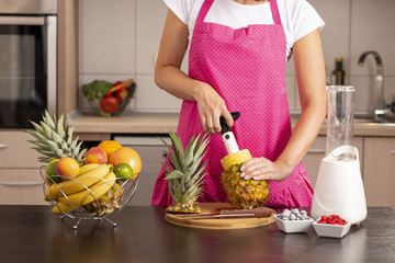 Woman using a pineapple cutter