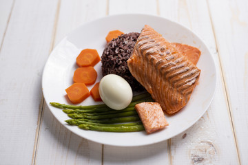 Health food concept, salmon with rice and vegetable on wood background