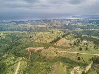 Fototapeta premium Widok z lotu ptaka na krajobraz Chile z dronu, wzgórz, dolin i nierównego krajobrazu z bliskiej odległości do nieskończonego horyzontu