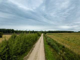 Fototapeta na wymiar drone image. aerial view of rural gravel road in green forest and trees with shadows from above